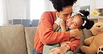 Happy, mother and child with hug, kiss and love for playful relationship bonding on living room sofa at home. Mama and kid playing together in happiness for loving care or joy relaxing on the couch