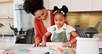 Mother, girl learning baking in kitchen and rolling flower dough on counter to cook cookies for fun, learning and development. Happy mom, black child with smile and teaching daughter to bake together