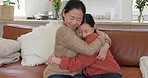 Love, hug and mother and daughter on sofa, spending time together in living room in Japan. Asian woman, child on couch in family home and happy relationship bonding with teenage girl on mothers day