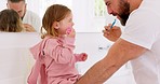 Father and child brushing their teeth with toothbrush together in bathroom of their home. Happy, dental care and man teaching his girl kid oral hygiene routine with toothpaste for health and wellness