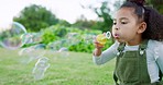 Happy girl kid blowing soap bubbles in park, garden and nature for playful fun, joy and childhood development, growth and sunshine relax. Laughing child, bubble wand and outdoor toy games in Brazil 