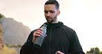 Fitness, running and drinking water with man in road for training, sports and workout in nature. Health, wellness and summer with runner and bottle in mountain outdoors for exercise, peace or freedom