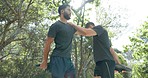 Fitness, exercise and stretching with sports friends getting ready for training or workout outside in a forest. Nature, trees and health with a man athlete and friend at the start of a cardio routine