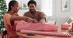 Christmas, gift and black couple packaging a box present with a ribbon to celebrate happy holidays at home. Smile, package and excited black woman wrapping gifts or presents with her African partner 