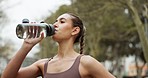 Drinking water, tired or woman in city fitness, workout or training in public garden, nature park or environment. Exhausted, break or fatigue runner with drink after sports exercise for muscle health