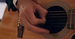 Hands, musician and playing on guitar strings in the studio at home for music production or performance. Hand of talented artist or professional acoustic guitarist with musical instrument for sound