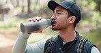Water, drink and man with fitness hiking, exercise and thirsty in forest, nature and woods. Motivation, health and training with man hydrate after hike in nature environment for health, and wellness