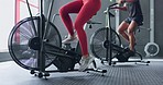 Man, woman and air bike machine in gym workout, team training or fitness for cardiology health, heart wellness or endurance. Spin class, cycling friends or sports people legs in body energy exercise