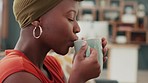 Relax, aroma and black woman drinking her coffee with satisfaction, happiness and joy. Delicious, aromatic and girl on coffee break sitting on sofa, mug in hand and relaxing with hot beverage at home