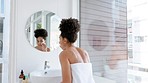 Skincare, bathroom beauty and woman in mirror for morning skin care facial treatment. Health, wellness and black woman in towel cleaning face, luxury detox product after shower and self care at home.