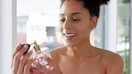 Perfume, smell and scent with a black woman spraying a product on her skin or body in the bathroom of her home. Luxury, cosmetics perfume bottle with a happy female using spray for a fresh aroma