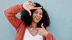 Picture frame hands or fingers with woman pose, smile and having fun on blue background and wall mockup. Young playful gen z or millennial beauty model photo capture framing gesture in funky portrait