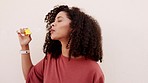 Young woman, fun bubbles and happy casual smile on white background. Happiness laughing face with liquid soap, easy magic party material and afro hair girl blowing bubble wand with happiness freedom