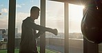 Man, boxing bag and mma with training, exercise and workout with gloves, fitness and punch for match or competition.  Sports male or athlete doing self defense, strength and cardio during sunset