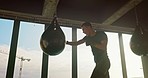 Man, boxing bag and punching in gym workout, training and  exercise fro anger management, stress control or strong muscle growth. Boxer, sports athlete and fitness mma fighter in self defense cardio