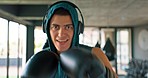 Sports, fitness and portrait of man boxing with headphones  on for practice in gym. Exercise, workout and male athlete with boxing gloves for kickboxing training, listening to music, track and audio