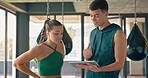 Tablet, coach and woman planning workout, talking and discussion for health, wellness and fitness in gym. Digital device, trainer and female athlete have conversation for exercise routine or training