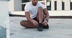 Fitness, man and shoes in sports motivation, exercise or workout for roof top training in the city. Athletic male tying shoe laces ready for cardio wellness, health or sport practice in a urban town