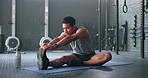 Man, break and stretching on gym floor in fitness, workout or training for strong muscles, heart health or cardio wellness. Japanese personal trainer, sports person or coach in body warmup exercise