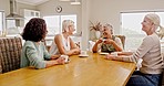 Friends, talking and visit with a senior woman group sitting around a table at home while drinking tea or bonding. Relax, conversation and retirement with a mature female and friend talking together