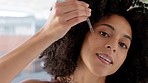 Skincare, beauty and black woman with face serum in bathroom for glowing skin. Wellness, health and female apply hyaluronic oil with pipette or dropper product for facial treatment or moisturizing.

