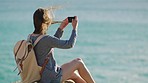 Phone, woman and beach photography while travel, backpacking and exploring nature, happy and relax. Sea, girl and selfie at ocean by backpacker on adventure, taking photo of water, scenery and view