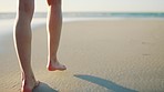 Feet, walking and on beach to relax, wellness and calm for holiday, seaside and rest. Walk, peaceful and legs on shoreline for stroll, on sand or weekend trip for break, summer or travel for vacation