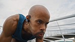 Athlete, start and race with focus for fitness, success and training outdoor with earphones for music. Black man, runner and ready for competition, contest or running for health, wellness or exercise