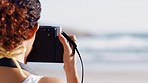 Woman, photographer and beach for photo view, capture or destination in travel, trip or sightseeing in the outdoors. Female photography taking picture of the ocean coast for traveling memory at sea