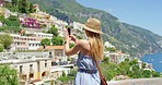 A young woman making a video on her smartphone of her holiday destination