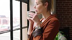 Thinking, window and coffee with a business woman drinking a beverage from a mug in her office at work. Startup, idea and a female employee contemplating future growth with a vision mindset