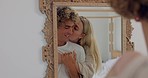 Mirror, love and kiss with a couple talking while looking at their reflection together in the home. Smile, affection and romance with a man and woman kissing or bonding in the bathroom of their house