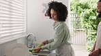 Woman, food and couple cleaning vegetables in kitchen at home while talking, healthy and happy for cooking together with love. Black man and partner washing celery with clean tap water in new house