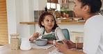 Mother, girl and eating cereal in the morning, talking and happy together at home. Mama, daughter and breakfast with conversation, bonding and speaking with fun, happiness and family in kitchen.