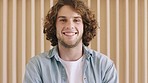 Man, face and smile while happy, laughing and positive mindset against a wall for motivation as an exchange student. Portrait of a young male from Australia with curly hair and carefree attitude