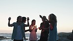 Friends group, beach and sparklers for celebration, party or happiness for new year by sunset together. Happy, group of people and fireworks in hands with diversity, vacation and ocean in summer