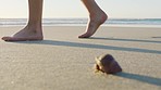 Person feet, walking and beach in sand steps, sea shell and summer vacation, holiday and tropical sea travel in Hawaii. Legs, foot or relax ocean water shore, freedom and calm in nature with freedom
