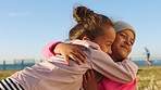 Friends, girls hug and beach for vacation, playful or happy for weekend break, relax or cheerful. Young females, kids and embrace for happiness, seaside holiday and outdoor for fun, grass and freedom