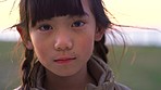 Child, face and outdoor in nature park sad, lost and lonely while lost, homeless and scared or fear with refugee problem and poverty. Portrait of asian girl with anxiety and upset about bullying