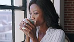 Black woman, drinking coffee and window in apartment for relaxed morning and smile at home. Portrait of African American female enjoying a warm drink, thinking and smiling while relaxing indoors