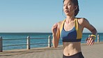 Asian woman, music earphone or running by ocean sea or water waves in Singapore healthcare wellness, cardio or marathon training. Runner, fitness or sports athlete listening to workout exercise radio