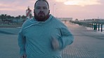 Running, music and fitness with overweight man for losing weight, challenge and cardio endurance. Weight loss, motivation and streaming with plus size runner at beach for health, wellness and stamina