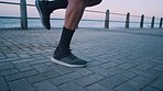 Feet, man and running on spot outdoor at beach promenade for energy, power or start healthy exercise. Closeup runner, shoes and feet with warm up in place at ocean for cardio sports, fitness and legs
