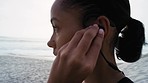 Fitness, exercise and woman with earphones at the beach listening to music, radio and audio for workout. Running, healthy lifestyle and profile of girl with headphones for marathon training by ocean