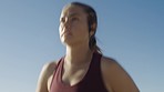 Woman, running and face of an athlete outside for fitness workout and sports body goal. Run, blue sky and athletic or sporty female in sportswear with runner dedication for a healthy lifestyle