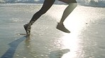Legs running, fitness and beach waves for workout outdoor, marathon training motivation and cardio exercise. Athlete person, strong runner leg and costal sports wellness on Australia ocean sand