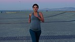 Fitness, running and pregnant woman outdoor with body wellness, self care and healthcare for development, progress and growth. Healthy, diet and pregnancy runner or athlete cardio on a beach sidewalk