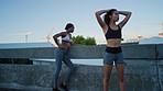 Fitness, exercise and tired women friends running outdoor for health and wellness with cardio training on city bridge together. Black woman and workout partner breathing after urban run in Cape town