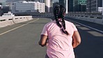 Running, runner and woman with fitness in street, city and exercise outdoor. Sweat, cardio and energy with plus size athlete and weightloss. Wellness, urban and workout with run and sports back view.