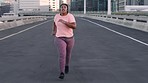 Fitness, music and plus size woman running in road for wellness, health and cardio in city. Black woman, run and weight loss in street for training, workout and exercise with podcast, radio or track